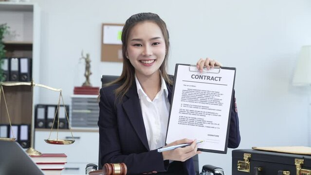 Asian legal compliance, faculty of law, legal counseling office, a female lawyer reads contract, advising on legal matters.clients, ensuring agreements align with laws and regulations, sign a contract