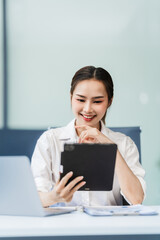 In the office, a businesswoman, accountant by profession, works on financial documents. She uses a computer to calculate income, analyze data, and manage budgets. Asian people.