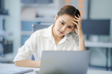 Asian people, In the corporate office, a young businesswoman sits at her desk, feeling exhausted...