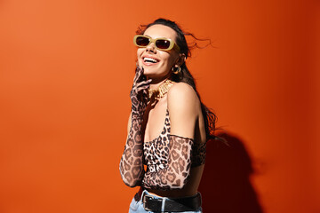 A stylish woman rocks a leopard print top and sunglasses, exuding summertime charm against an...