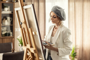 Beautiful female painter enjoying while painting in home art studio. Woman Artist Works on Abstract acrylic painting in the art studio - 782159843