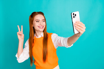 Photo of lovely positive girl blogger dressed trendy orange clothes talk webcam v-sign isolated on...