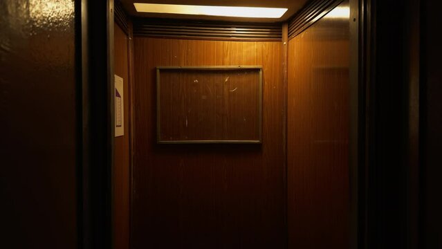 A scary elevator in a building with hardwood walls in old buildings