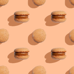 Seamless pattern with beige color macaroons on a peach fuzz background