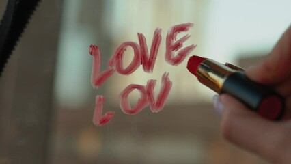 sexy girl writes a love message on the mirror and glass with red lipstick. The phrase I love you on the first date of a man and a woman. Erotic and romantic atmosphere with hearts and black lace bra