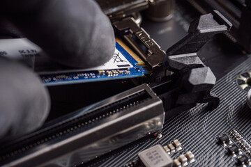 a specialist installs a solid-state drive in the m2 connector - obrazy, fototapety, plakaty