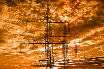  high voltage electric poles against sky with dramatic clouds - 782178801