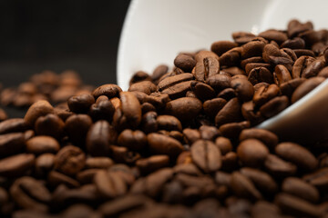 Coffee beans on warm light with white cup