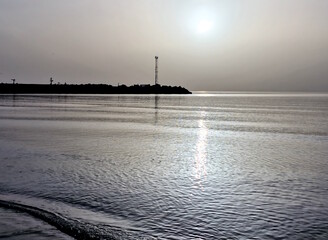 Amazing natural effect of the sun in the haze, which created a unique silver color and its reflection in the sea. Baltic sea.