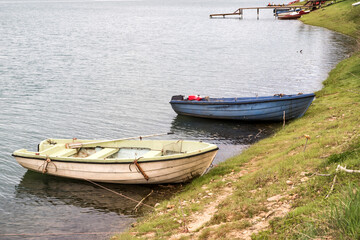 Vintage fishing boats tied to the shore of a lake