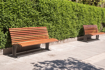 Outdoor furniture wooden park bench seats closeup on sunny day