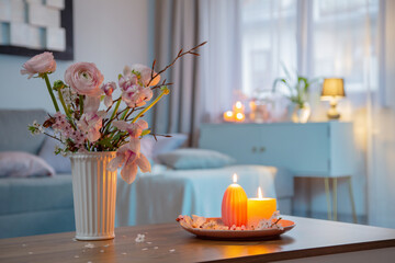home interior with spring flowers and burning candles - 782188429