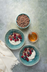 Breakfast, two bowls, yogurt, muesli with berries, and honey, homemade, no people,