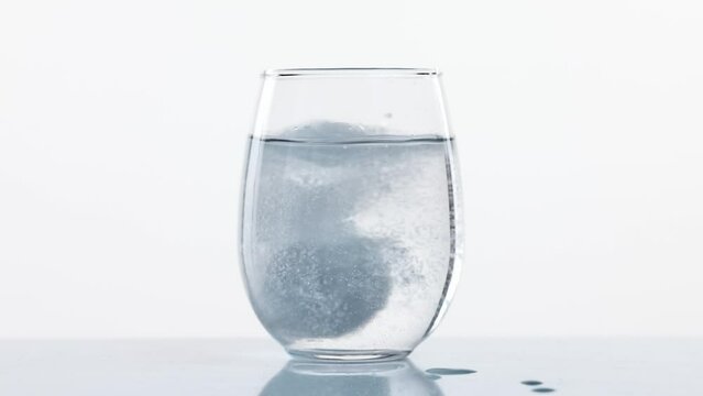Tablet dissolving in glass of water. Fizzy pill is in glass of water. Painkiller. Concept of refreshment, health, wellness, hydration, vitamins, treatment