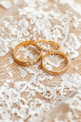 Obraz na płótnie Canvas Elegant gold wedding rings displayed on a delicate lace tablecloth. Perfect for wedding invitations or bridal websites