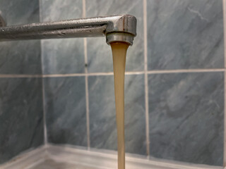 Brown water flows from the tap. Rusty water, bad water flows from the tap.