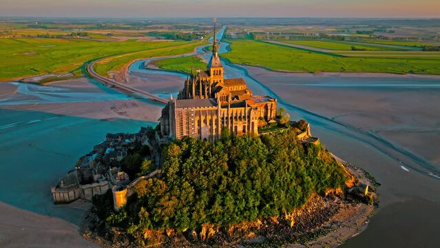 Aerial view of the highest tides in Europe. The Abbey of Mont-Saint-Michel in Normandy, France. Aerial view of French mountain at golden sunset.