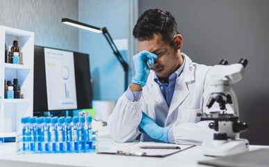 A scientist who is trying in the lab, he is working too hard but is not successful in his...