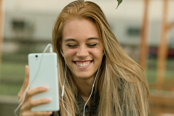 Beaming, girl shares laughter through her smartphone