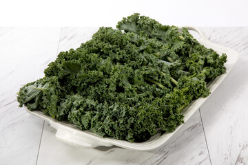 A tray of green fresh kale on a kitchen counter