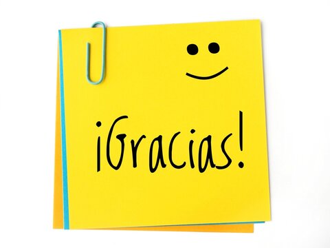 &iexcl;Gracias! handwritten on a yellow sticky note and a happy face.. Thank you in spanish