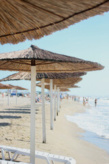 Straw umbrellas on a sunny summer day on the sea beach