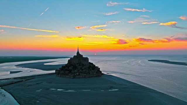 Aerial view of the highest tides in Europe. The Abbey of Mont-Saint-Michel in Normandy, France. Aerial view of French mountain at golden sunset.