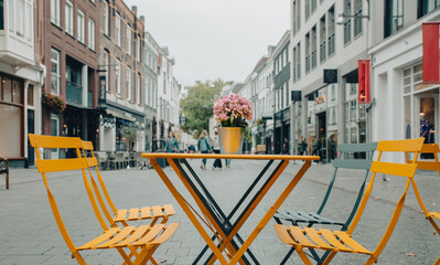 yellow bar chair and table on the street with flower, casual lifestyle, vacation, Netherlands