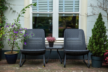 two garden chairs with flowers in front of window in a garden, lifestyle