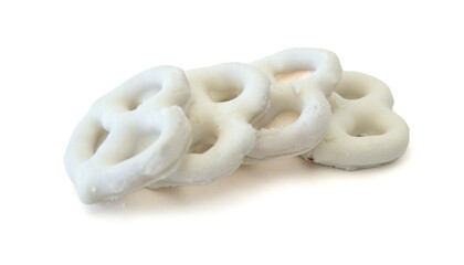 White chocolate covered pretzels on white background - 782220872