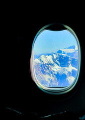 View of the snow covered Andes Mountains out the window of a plane