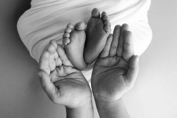 The palms of the father, the mother are holding the foot of the newborn baby. Feet of the newborn...