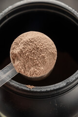 Chocolate protein powder in scoop. Food supplement, nutrition 