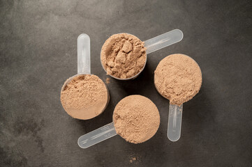 Chocolate protein powder in scoops. Food supplement, nutrition 
