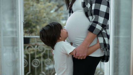 Small Boy Embracing Expectant Mother's Belly by Balcony, Tender Affection for Unborn Sibling