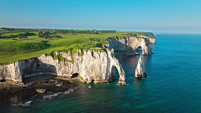 Aerial view of Towering white cliff featuring natural arch by the sea in France. Scenic view of Falaise d'Aval in Etretat, France. Rock formation by the water edge, scenic point tourist attraction.