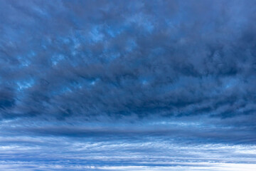 Dark rain clouds over sea horizon at sunset
