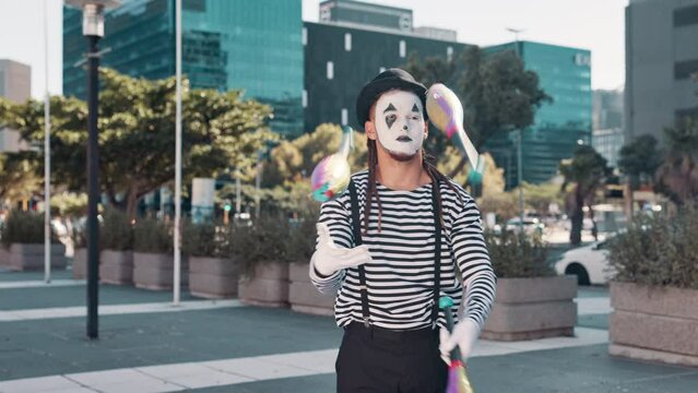 Juggling, mime and man in city for performance, entertainment and creative act in urban town. Street performer, theatre and person with pins juggle for festival, carnival and circus in costume