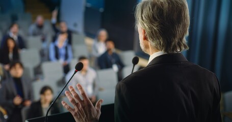 Back view of politician or activist pronouncing speech during press campaign in the conference...