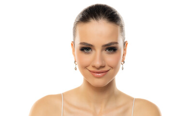 Portrait of a young smiling teenage girl with makeup on a white studio background