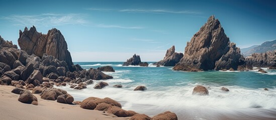 Fototapeta na wymiar Rocky shore with crashing waves and blue sky