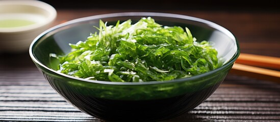 Obraz na płótnie Canvas Fresh green veggies with chopsticks, paired with seaweed salad