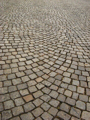 Circular placement of small square tiles on the pavement - obrazy, fototapety, plakaty