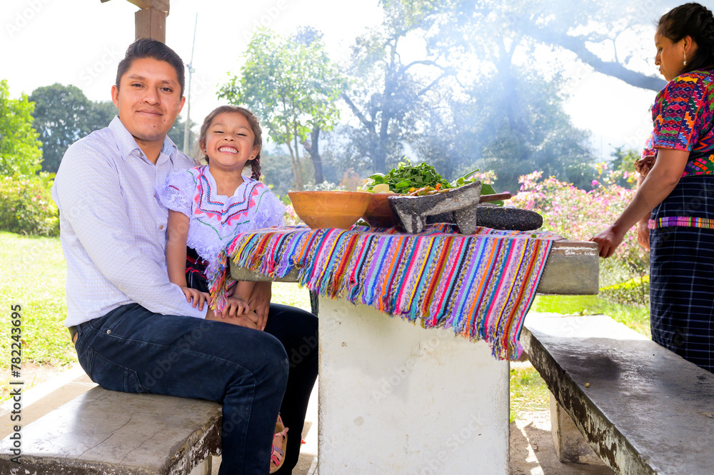 Wall mural portrait of father with his little daughter next to a table with vegetables and handmade kitchen ute