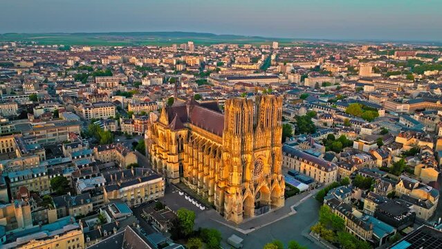 Gothic cathedral with twin towers at golden sunset in France. Reims city situated in a vine-growing country in which champagne wine is produced. Aerial view Cathedral of Notre-Dame of Reims, France.