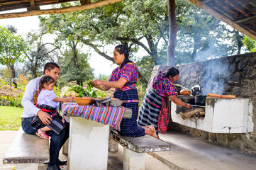 The father and mother teach their little daughter how traditional foods from their region in Latin America are made.
