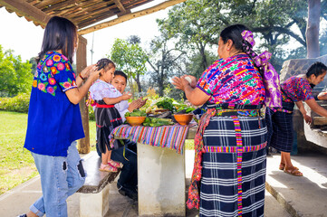 Everyone in the family makes small corn tamales with their hands, shares and learns.