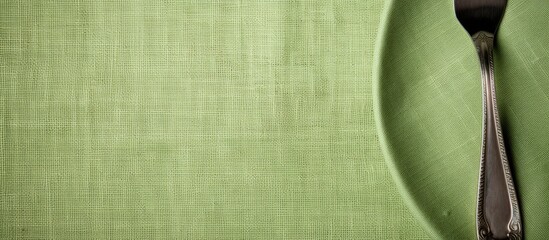 Green plate with silverware on green cloth
