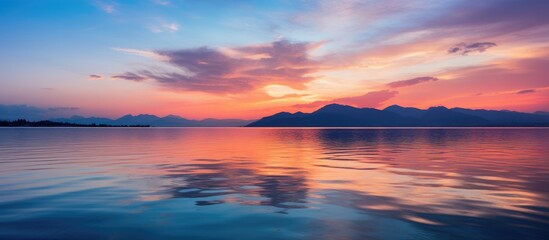 Fototapeta premium Sunset over Water and Mountains