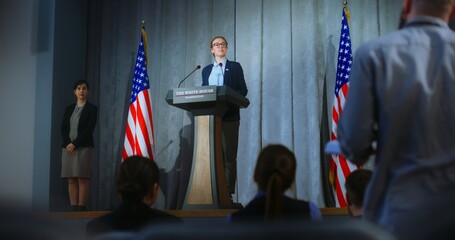 US presidential candidate makes an announcement, answers media questions, gives interview. Female American republican politician during performance at press conference. Backdrop with American flags. - obrazy, fototapety, plakaty